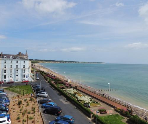 a parking lot with cars parked next to the ocean at Beaconsfield Holiday Apartments in Bridlington