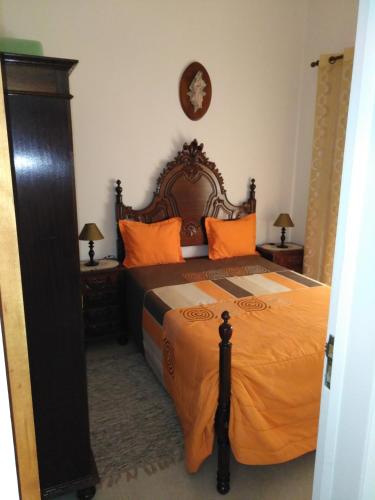 ナザレにあるMoradia Salesのベッドルーム1室(大型ベッド1台、オレンジ色の枕付)