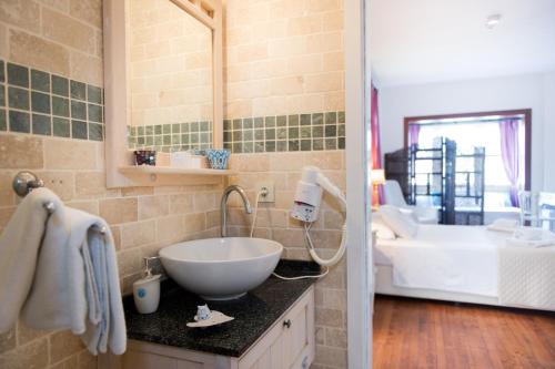 a bathroom with a sink and a bath tub at Otello Alacati in Alacati