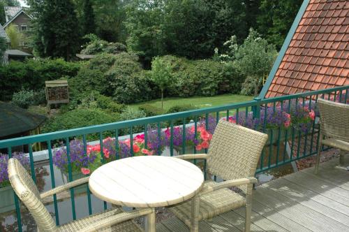 a table and two chairs on a balcony with flowers at Hotel Vierhouten in Vierhouten
