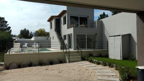 een groot wit huis met een zwembad bij Azar Departamentos Tandil in Tandil