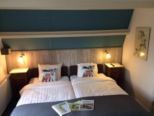 a bedroom with two beds with pillows on them at Hotel Vierhouten in Vierhouten