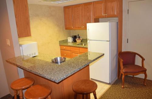 a kitchen with a white refrigerator and wooden cabinets at Stone Gate Inn in Orillia