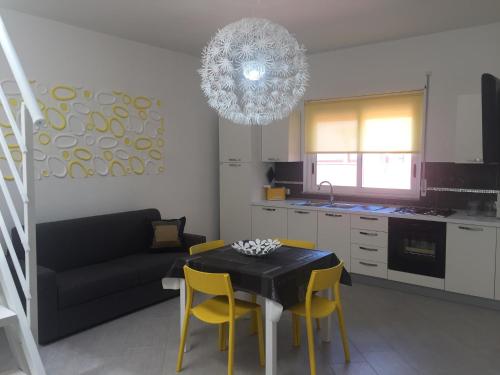 ein Wohnzimmer mit einem Tisch und gelben Stühlen in der Unterkunft Casa Vacanze Anna in Balestrate
