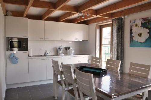 uma cozinha com mesa e cadeiras e uma cozinha com armários brancos em Zeepark Mercator em Wenduine