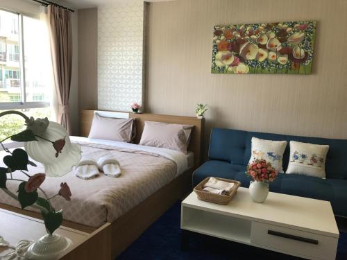 a bedroom with a bed and a blue couch at Baan Peang Ploen B411 in Hua Hin