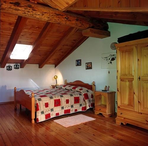 una camera da letto con un letto e un pavimento in legno di Villaggio Gerbore a Saint Nicolas