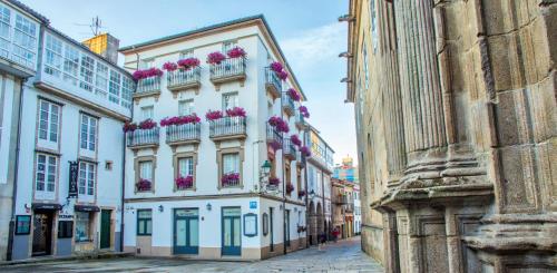 a building with flowers on the balconies on a street at Casa Celsa-Barbantes in Santiago de Compostela