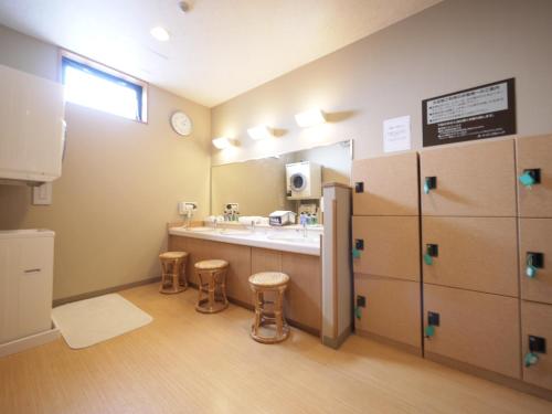 een badkamer met een wastafel, een spiegel en krukken bij Hotel Route-Inn Tendo in Tendo