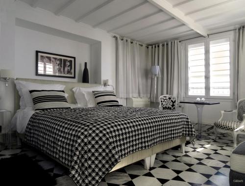 a bedroom with a bed with a black and white blanket at La Villa Bleue-Sidi Bou Said in Sidi Bou Saïd