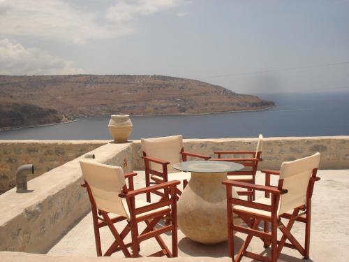 a group of chairs and a table on a ledge at Selana View in Karavostasion