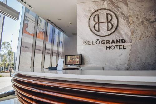a hotel lobby with a sign on the wall at Hotel Belo Grand Morelia in Morelia