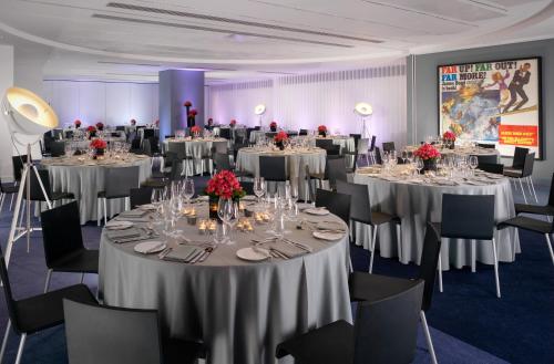 a banquet room with tables and chairs with tablesktop at Sea Containers London in London