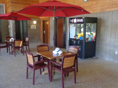 a restaurant with tables and chairs and a red umbrella at AmericInn by Wyndham Grand Rapids in Grand Rapids