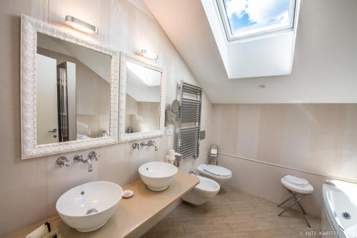 a bathroom with two toilets and a sink and a mirror at Hotel San Pietro Palace in Finale Ligure