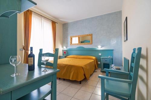Schlafzimmer mit einem Bett und einem Tisch mit Weingläsern in der Unterkunft Hotel San Francisco in Cala Gonone