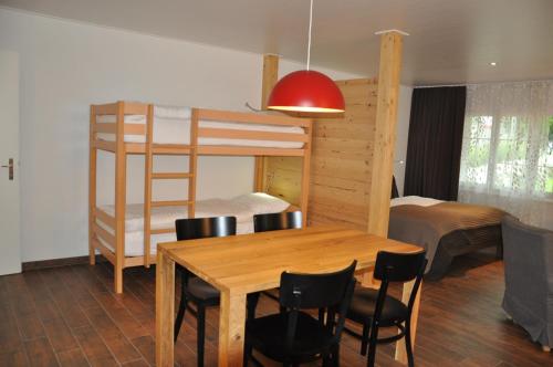 a dining room with a table and a bunk bed at Alte Bäckerei in Schwarzsee