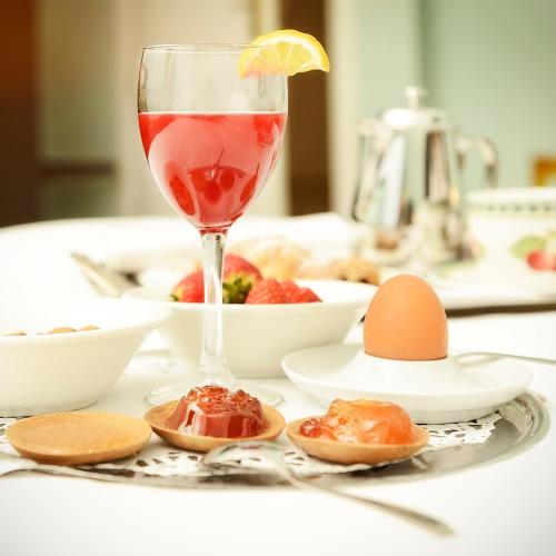 Una copa de vino sobre una mesa con comida. en Villa Susanna Degli Ulivi - Resort & Spa, en Colonnella