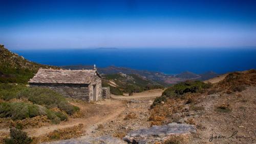 an old stone building on the side of a mountain at Hôtel U Pozzu in Sisco