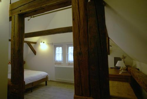 an attic room with a bed and a window at Chambres d'Hôtes La Stoob Strasbourg Sud in Illkirch-Graffenstaden