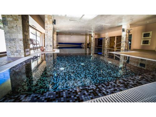 a swimming pool with rocks in the water at Park Hotel and SPA Vella Hills in Velingrad