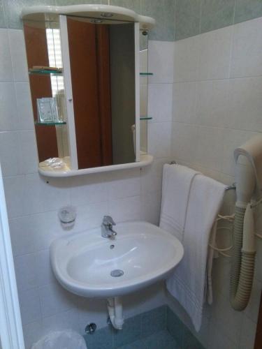 ein Badezimmer mit Waschbecken und Spiegel in der Unterkunft Hotel ILLI in Marina di Massa