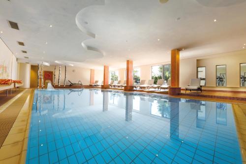 a large swimming pool with blue tiles on the floor at Hotel Grüner Wald in Freudenstadt