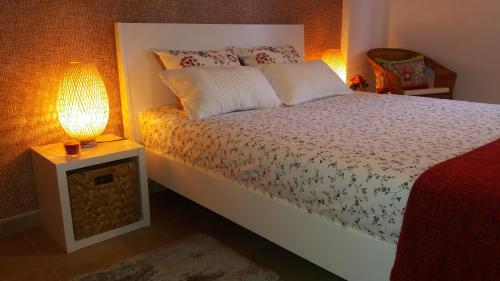 ヴィラ・ノヴァ・デ・ミルフォンテスにあるApartamento Praiamarのベッドルーム1室(ベッド1台、テーブルの上にランプ付)