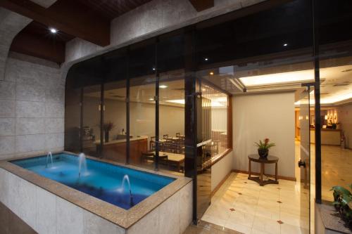 a large swimming pool in a building with glass walls at Hotel Moncloa in Sao Paulo