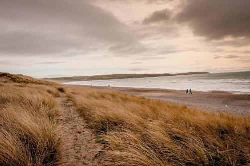 a group of people walking on the beach at The Wild Atlantic Hideaway in Clonakilty