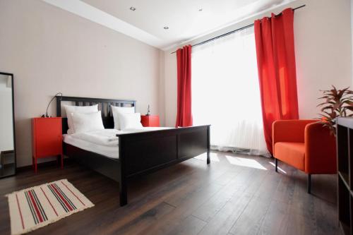 1 dormitorio con 1 cama y 2 sillas de color naranja en Standard Apartment by Hi5 - Close to Buda Castle, en Budapest