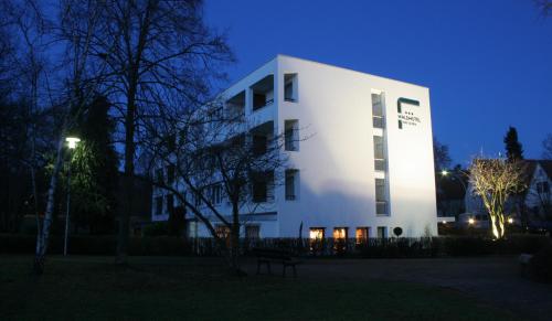 a white building at night with a blue sky at Waldhotel Bad Soden in Bad Soden am Taunus
