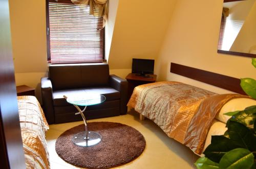 a bedroom with a bed and a chair and a table at Camping Motel WOK in Warsaw