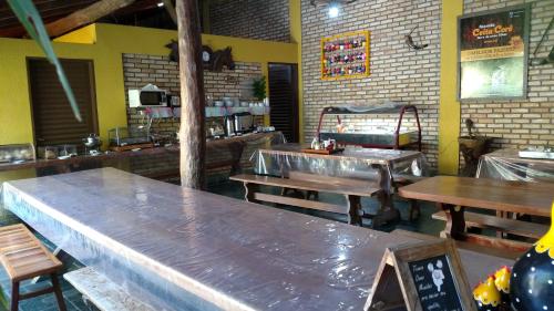 an empty restaurant with wooden tables and benches at Pousada Segredo in Bonito