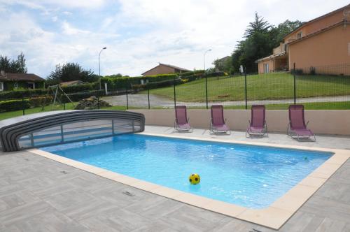 - une piscine avec des chaises et un ballon à l'eau dans l'établissement Aux 4 Saisons, à Tabre