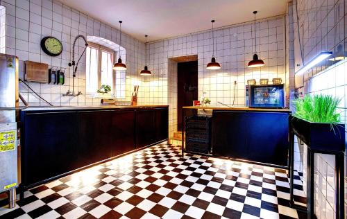 a kitchen with a black and white checkered floor at Hotel Villa Königsgarten in Siebeldingen
