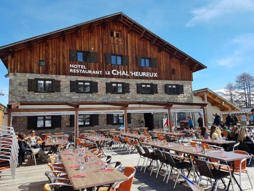a restaurant with tables and chairs in front of a building at le Chal'heureux in Vars