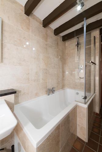 a bathroom with a white tub and a shower at Conwy Valley Cottages in Conwy