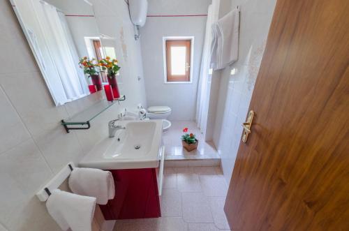 bagno bianco con lavandino e servizi igienici di Casa Vacanze "Ro & Se" a Palinuro IT, Bandiera Blu anche per il 2024 a Palinuro