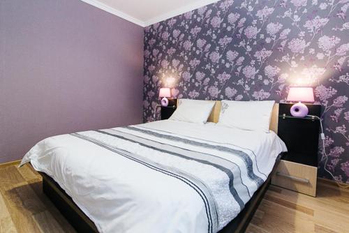 a bedroom with a large bed with purple walls at VIP Apartment ob Gorkogo Square in Sumy