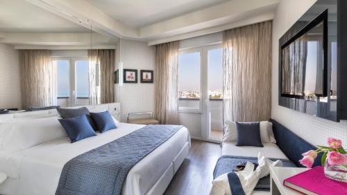 una camera d'albergo con due letti e una grande finestra di Hotel Nautico a Riccione
