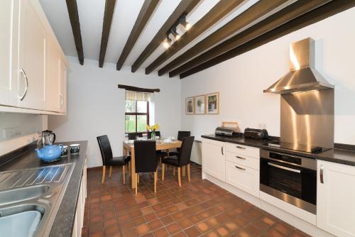 a kitchen with a table and some chairs in it at Conwy Valley Cottages in Conwy