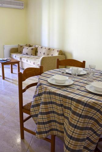 a dining room with a table and chairs and a couch at Evangelia in Ayia Evfimia