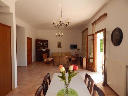 une salle à manger avec une table et un vase de fleurs. dans l'établissement Kaina Villa, à Vámos