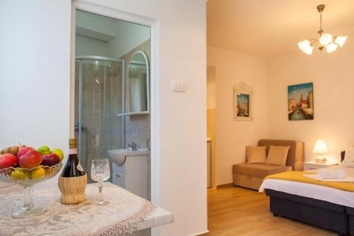 a room with a bed and a table with a bowl of fruit at Apartments & Rooms Jelka in Kotor