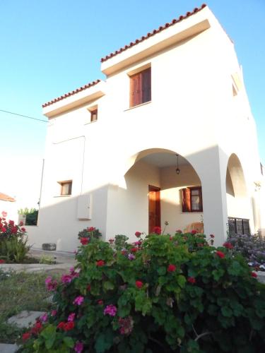 a white house with flowers in front of it at Kaina Villa in Vamos