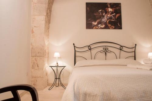 a bedroom with a bed and a painting on the wall at Le Dimore del Finoglio in Conversano