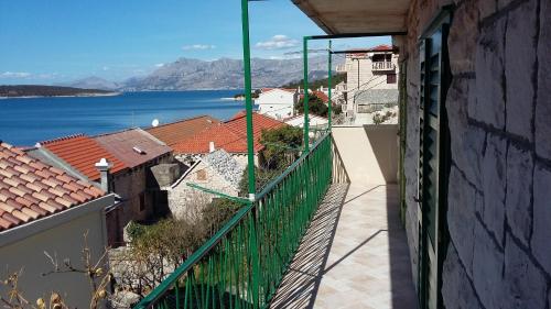 a balcony with a view of the water and buildings at Apartment Antica in Povlja