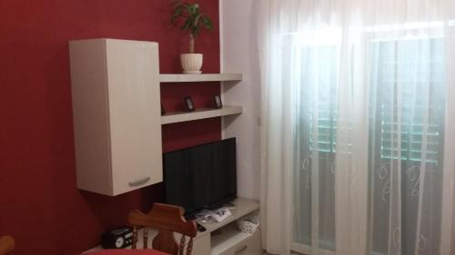 a living room with a tv and a window at Apartment Antica in Povlja