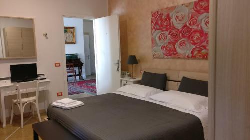 a bedroom with a bed and a desk with a computer at Casamare Hotel in San Vincenzo